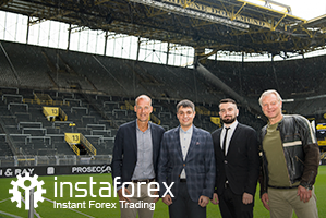 Legend of Borussia Dortmund Wolfgang de Beer, Business Development Director of InstaTrade Pavel Shkapenko, Business Development Director of InstaTrade for Asia Roman Tcepelev and CEO of Borusssia Carsten Cramer in front of the largest free-standing grandstand in Europe located in southern terrace of SingalIduna Park Stadium